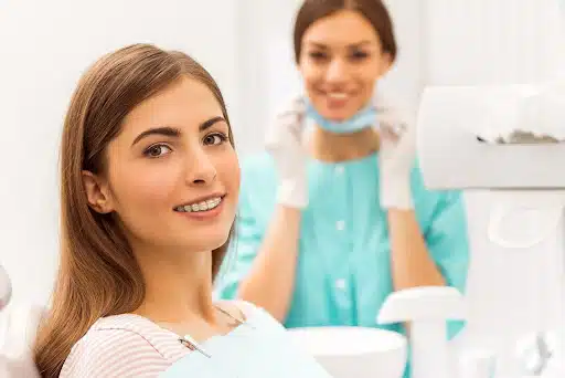 Patient smiling with braces in a dental office, showing braces progress month by month